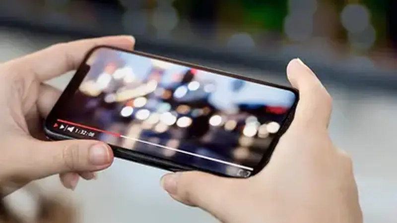 Hand downloading a video on a smartphone closeup